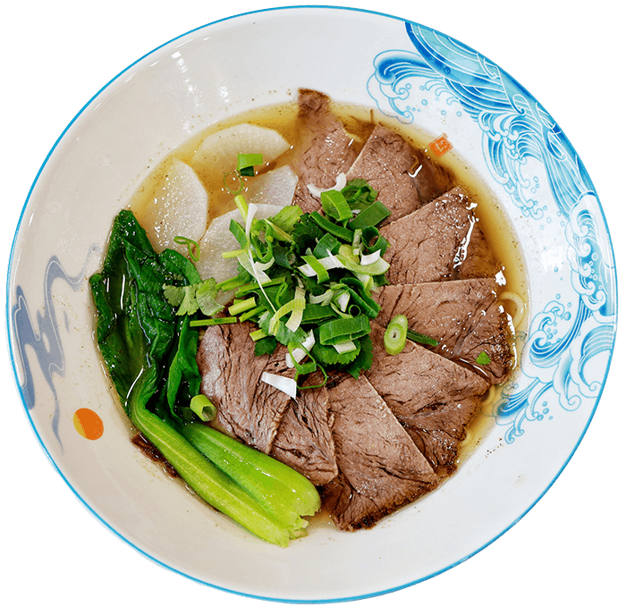 Weiße Schüssel von oben zeigend mit Nudeln, Fleischfilets, Pak Choi und Lauchzwiebeln in einer Brühe